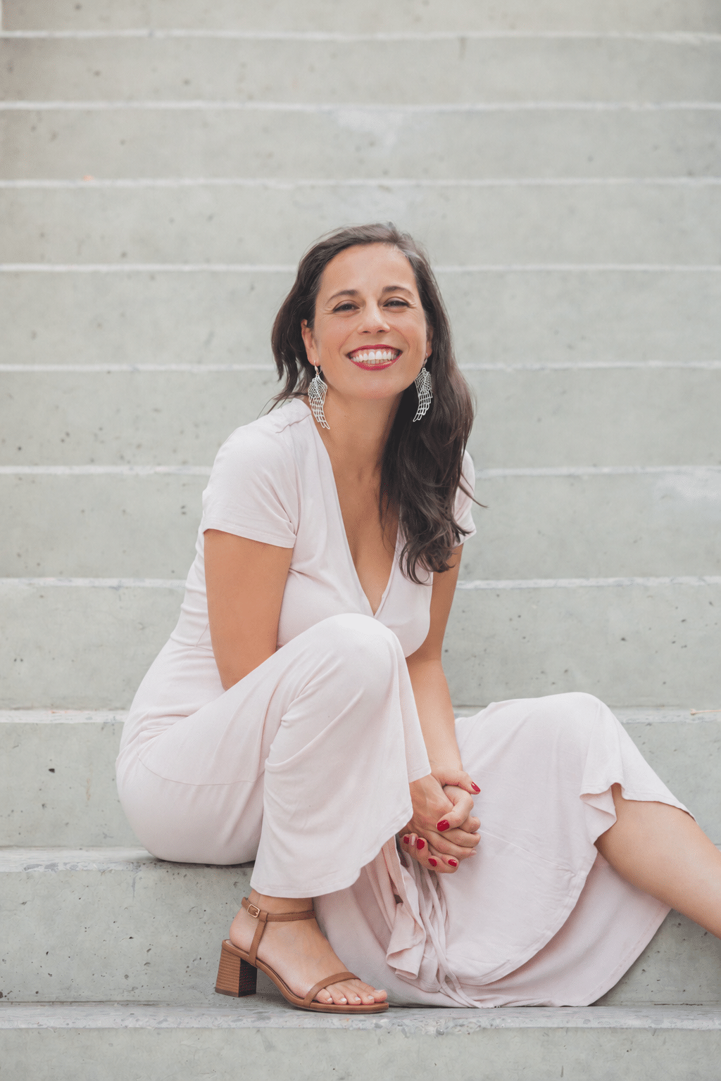 Marcela Moreno sonriendo, sentada en unas escaleras